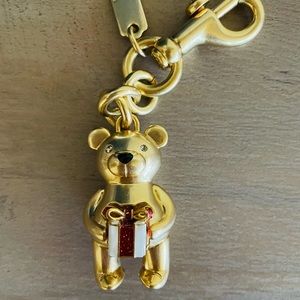 Coach Christmas bear charm holding a present